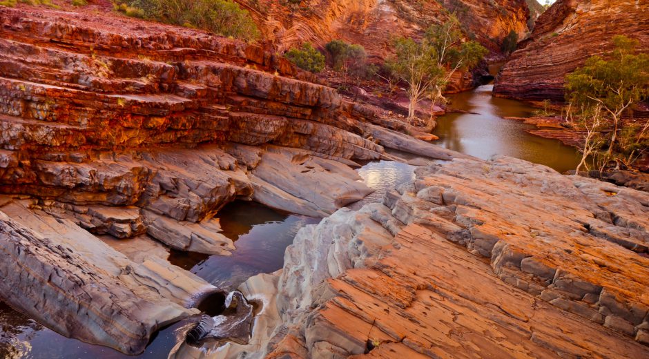 One of the most stunning gorges at Karijini National Park in Western Australia. The bright red rocks bring a calming glow to the series of pools along the river.